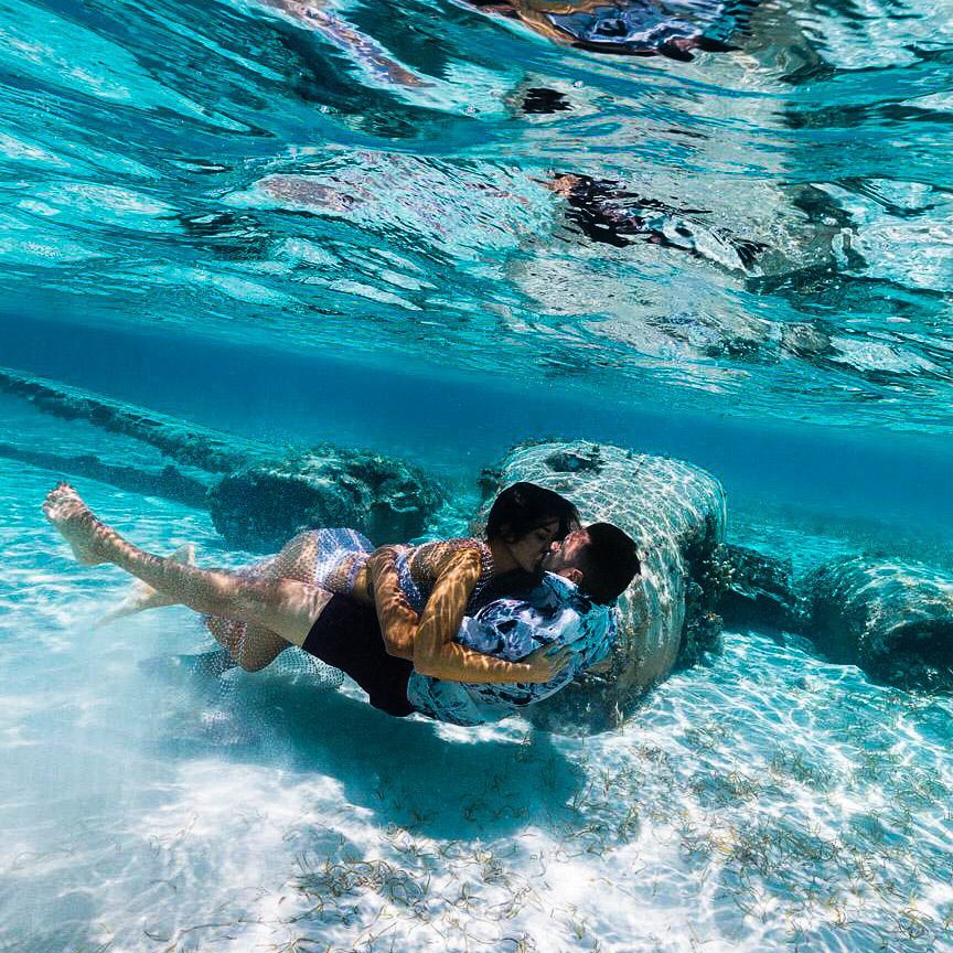 A couple sharing a passionate kiss while swimming under the crystal-clear waters of the Caribbean.