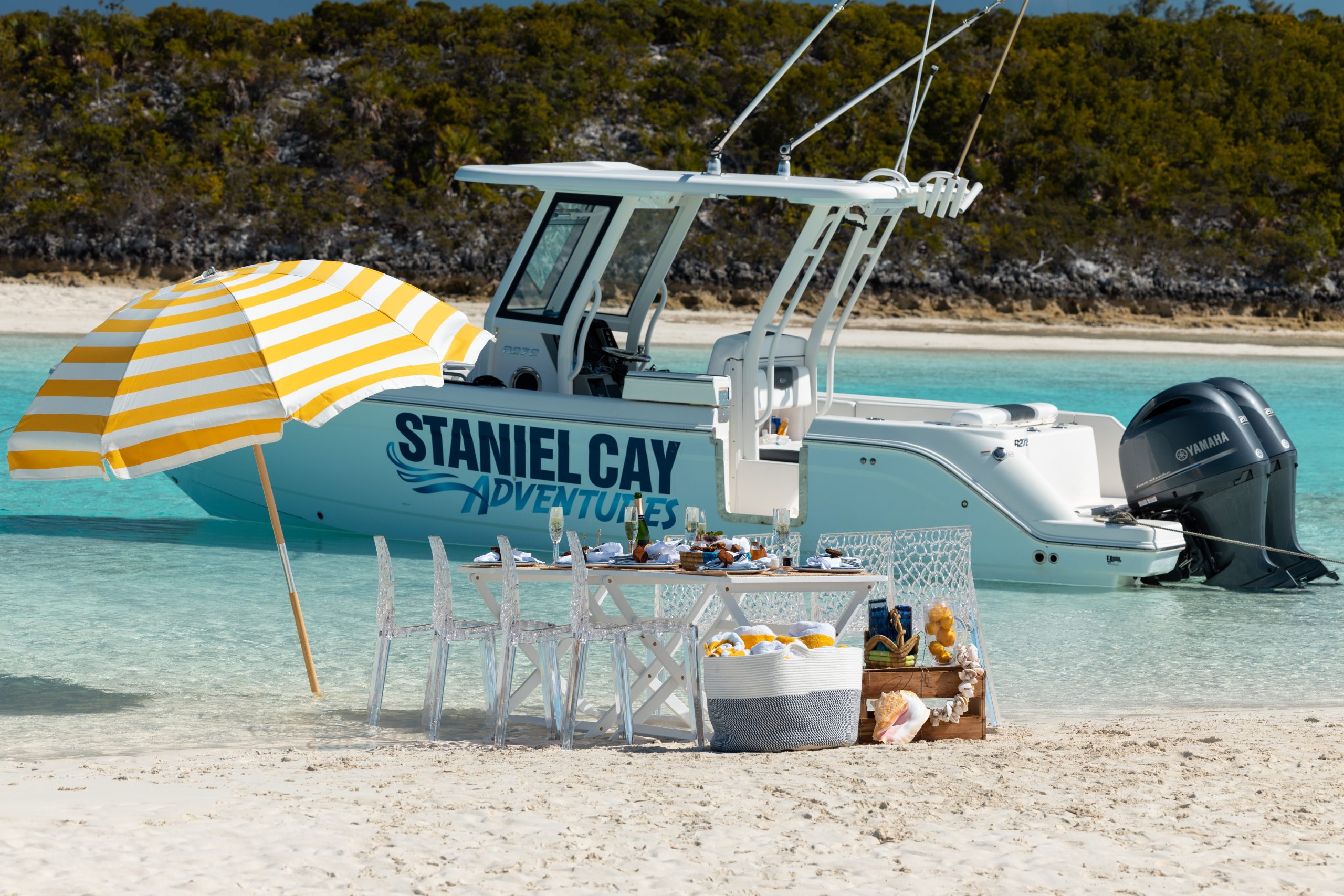 A boat with a table and chairs on the beach, available for Staniel Cay Tours.
