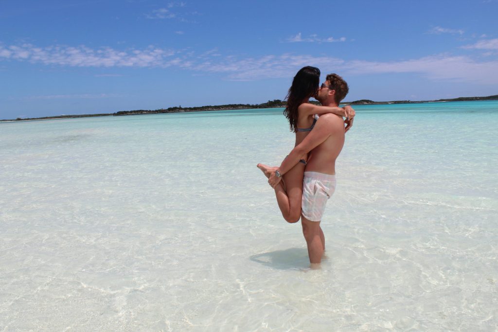 A man and woman enjoying Staniel Cay beach.