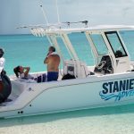 Two people enjoying Staniel Cay Adventures on a boat in the ocean.