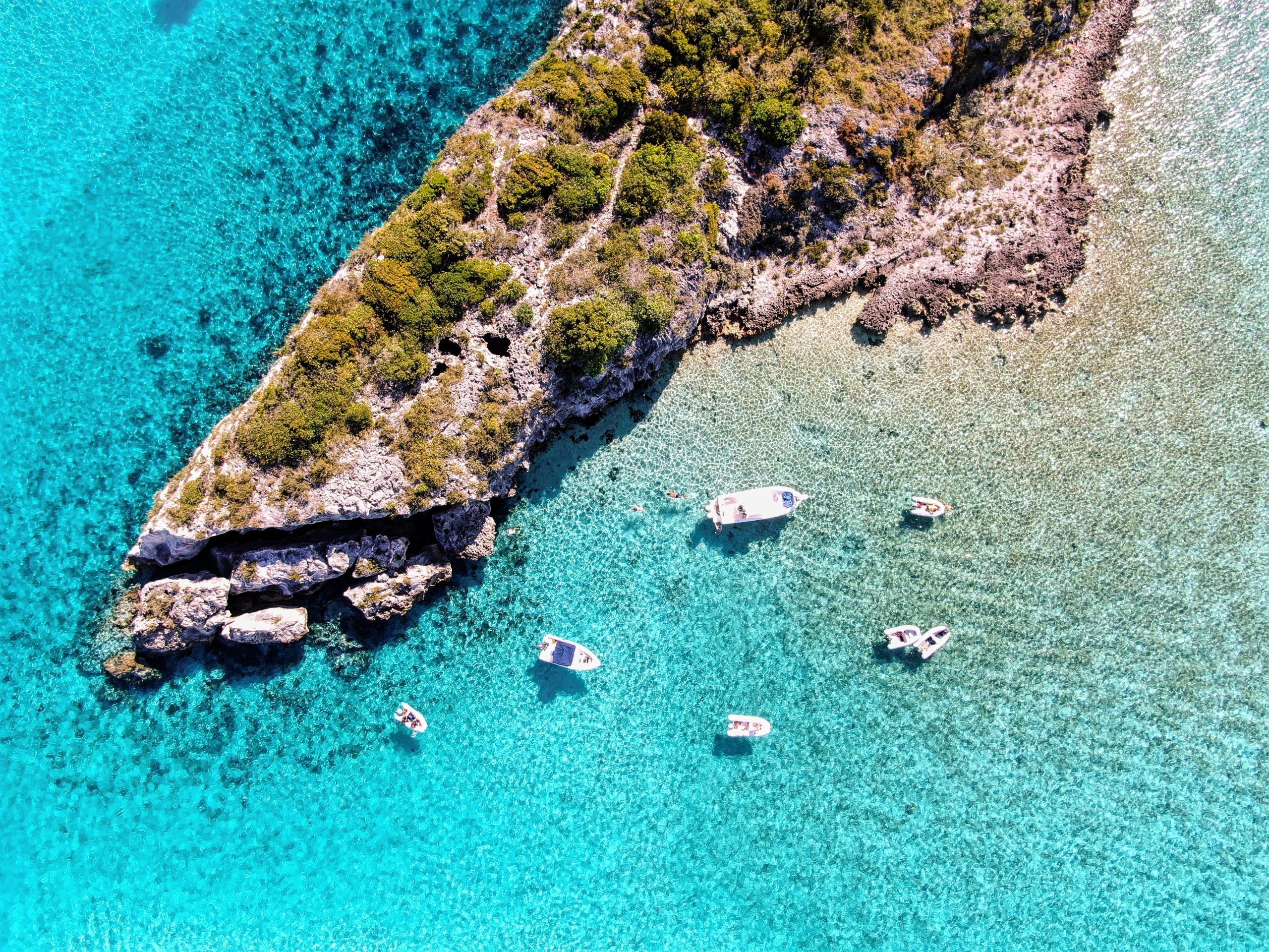 An aerial view of a small island with boats in the water, perfect for those interested in Staniel Cay Adventures or Scuba Diving Exuma.