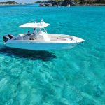 A white boat is floating in the clear blue water during a Staniel Cay Adventures tour.