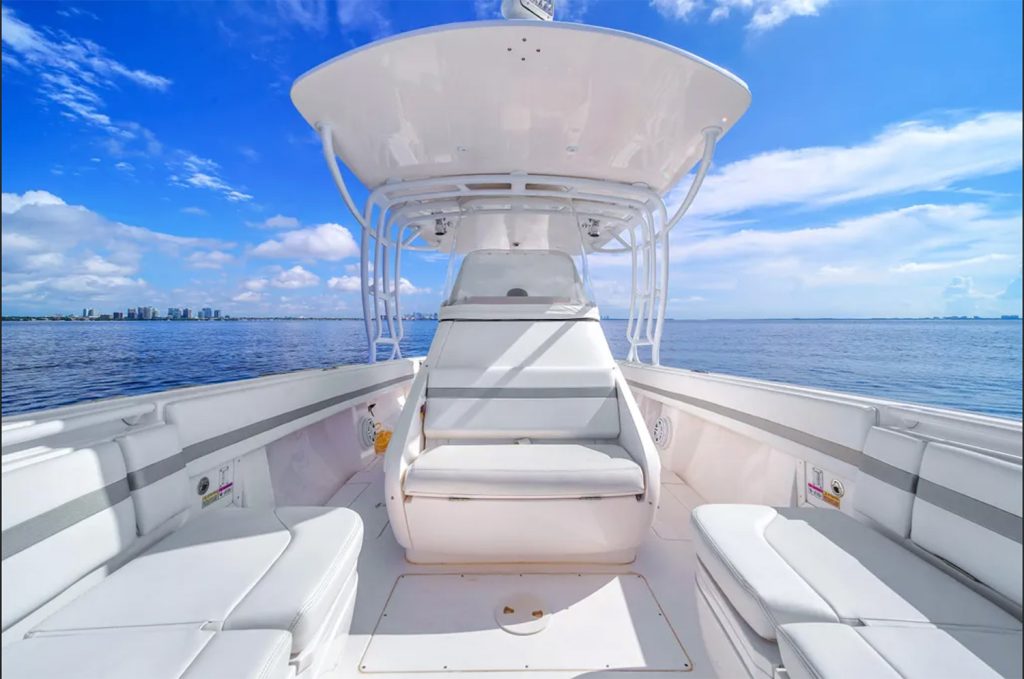 Staniel Cay, Exuma Bahamas View from the deck of a white motorboat with cushioned seating and a shaded canopy, floating on calm water under a partly cloudy sky. Swimming Pigs Tours, Fishing and more!