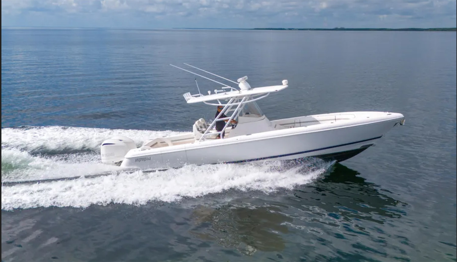 Staniel Cay, Exuma Bahamas A white motorboat with two outboard engines moves quickly across calm water under a partly cloudy sky. Swimming Pigs Tours, Fishing and more!