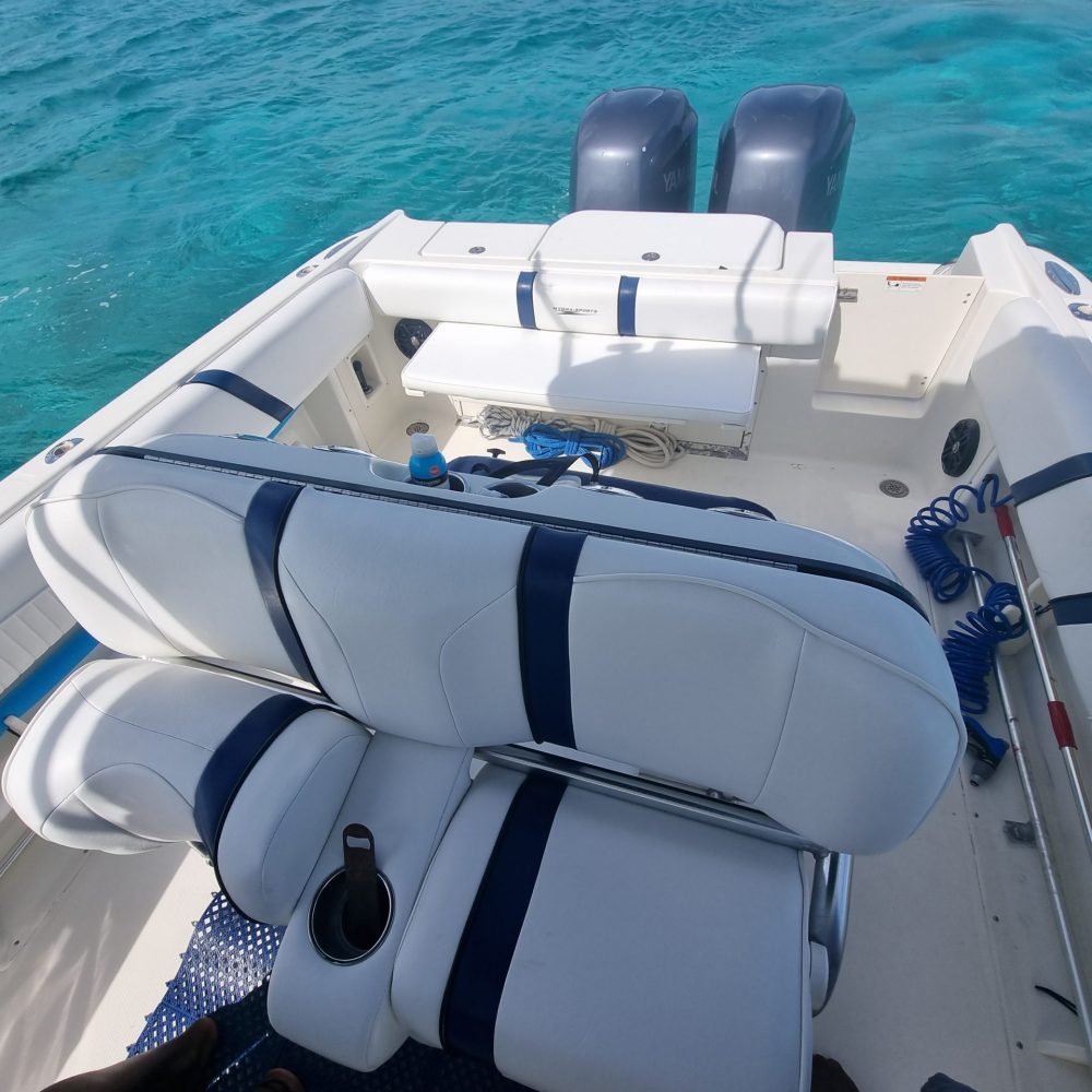 Staniel Cay, Exuma Bahamas View of a boat's seating area and two outboard motors, surrounded by clear blue water.