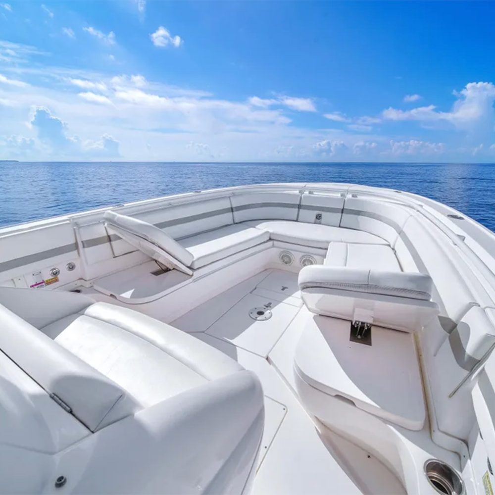 Staniel Cay, Exuma Bahamas The bow seating area of a white boat on calm blue water under a bright sky with scattered clouds. Swimming Pigs Tours, Fishing and more!