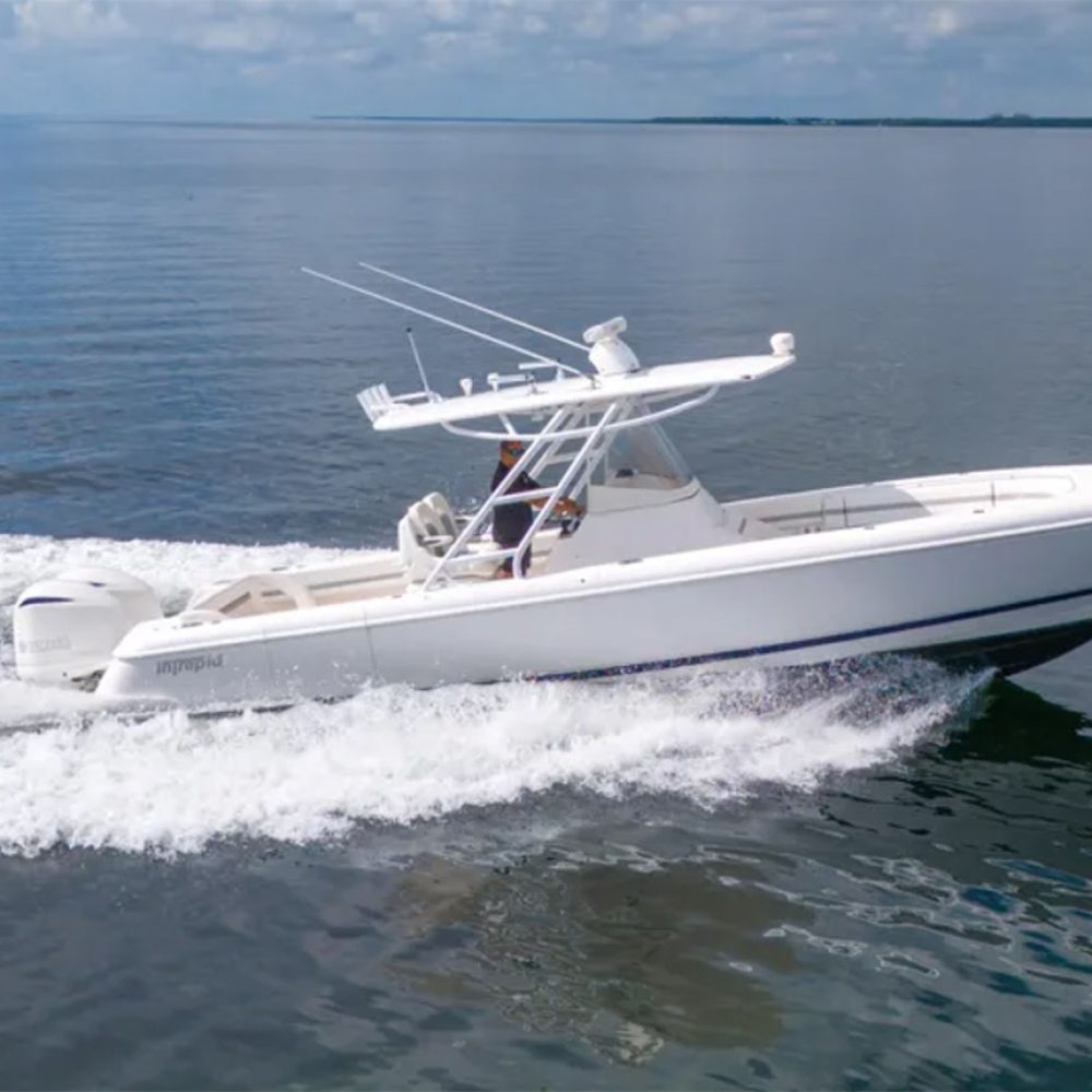Staniel Cay, Exuma Bahamas A white motorboat with two outboard engines moves quickly across calm water under a partly cloudy sky. Swimming Pigs Tours, Fishing and more!